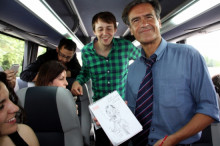 L'eurodiputat del PSOE Juan Fernando López Aguilar mostra el dibuix del president espanyol, Mariano Rajoy, amb el candidat Javi López, en l'autocar que han compartit amb periodistes