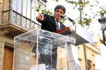 El president de la Generalitat, Carles Puigdemont, amb una urna al costat, en un acte del PDeCAT