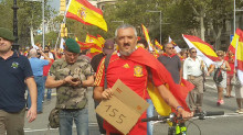 Un home subjecta un cartell amb el 155 dibuixar a la marxa unionista del 12-O a Barcelona