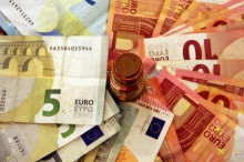 Una pila de bitllets amb una torre de monedes d'euro al centre