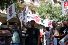 Pla contrapicat de manifestants amb pancartes a favor del SÍ al carrer Casp de Barcelona, davant la seu de la CUP