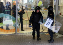 Agents de la policia espanyola al costat de la façana de l'Escola Nostra Llar un cop han trencat un vidre de la façana del centre