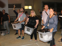 Diverses persones mostren les urnes amb sobres sense papereta un cop acabades les votacions a l'Institut Antoni de Martí i Franquès de Tarragona