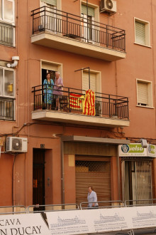 Veïns d'un carrer per on ha passat la Vuelta, amb una estelada i una senyera al seu balcó