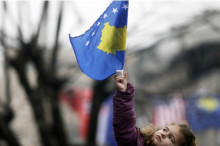 Una nena oneja la bandera de Kosovo a Prístina