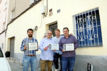 Els copropietaris de Petrolis Independents, Joan Canadell (a l'esquerra) i Jordi Roset (a la dreta) amb dos col·laboradors que mostren les tres plaques franquistes despenjades