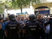 La policia espanyola envoltant la seu de la CUP, mentre simpatitzants criden en contra de l'actuació i en favor de l'1-O