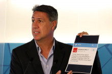 Pla curt del president del PPC, Xavier García Albiol, mostrant un paper amb una piulada del PSC