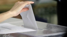 Una persona diposita un vot a una urna