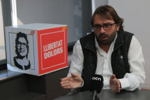 Pla mig del secretari general d'UGT a Catalunya, Camil Ros, amb un cartell de 'Llibertat Dolors' al fons, durant l'entrevista amb l'ACN
