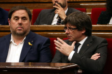 El president de la Generalitat, Carles Puigdemont, parla amb el vicepresident, Oriol Junqueras, al Parlament