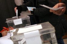 Dues persones introdueixen el seu vot en una urna