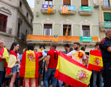 Pla contra-picat de manifestants unionistes a Reus amb banderes espanyoles davant un edifici ple de banderes catalanes, estelades i consignes pel Sí al referèndum