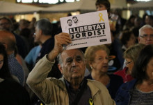 Pla mig d'un home amb un cartell per la llibertat de Sànchez i Cuixart a Reus. Imatge del 21 d'octubre de 2017