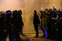 Pla general d'un manifestant encarant-se al cordó policial dels Mossos d'Esquadra prop de la delegació del govern a Barcelona poc després d'una càrrega policial