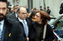 Pla mitjà de Jordi Turull i la seva esposa sortint del Tribunal Suprem envoltats de periodistes