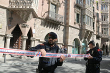 Dos agents dels mossos d'esquadra acordonen els voltants de la casa de les punxes mentre la Guàrdia Civil escorcolla la seu del Diplocat