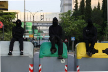 Tres estudiants dalt de contenidors en una barricada en un dels accessos principals a la UAB