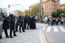 Pla general dels antiavalots de la policia espanyola, a la plaça Imperial Tàrraco, amb una multitud fent pressió perquè marxin