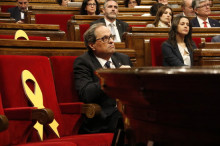 El president de la Generalitat, Quim Torra, assegut a la bancada de Govern amb el llaç al costat