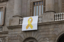 Pla mig de la pancarta amb el llaç groc que hi ha a la façana de l'Ajuntament de Barcelona