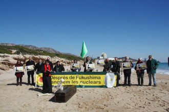 Concentració d'entitats ecologistes per commemorar l'accident de Fukushima. Darrere, la central nuclear de Vandellòs II.