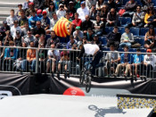 Un atleta de bmx salta davant d'un dels assitents que mostra l'estelada.