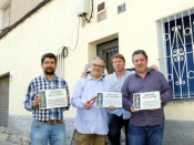 Els copropietaris de Petrolis Independents, Joan Canadell (a l'esquerra) i Jordi Roset (a la dreta) amb dos col·laboradors que mostren les tres plaques franquistes despenjades