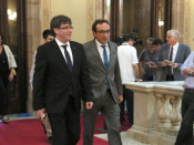 El president de la Generalitat, Carles Puigdemont, al costat del conseller de Territori i Sostenibilitat, Josep Rull, als passadissos del Parlament