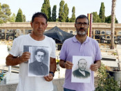 Pla mitjà del president de l'associació de familiars de víctimes del franquisme de la Fossa 113 de Paterna Santi Vallès (dreta) i un altre dels familiars, Miguel Esteve, posen al cementiri amb fotografies dels seus avantpassats
