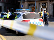 Un vehicle amb agents de la Guàrdia Urbana davant del cordó policial del carrer Pelai de Barcelona