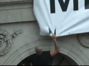 Imatge d'un jove intentant arrencar la pancarta de "Democràcia"