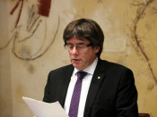Primer pla del president de la Generalitat, Carles Puigdemont, llegint un informe al Consell Executiu