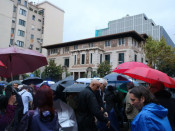 Els concentrats amagats de la pluja sota els paraigües durant l'acte reivindicatiu davant la delegació del govern a Barcelona