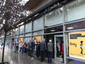 Cua davant un caixer automàtic de Caixabank a Barcelona