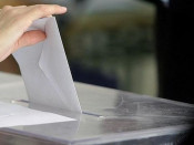 Una persona diposita un vot a una urna