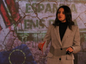 Primer pla d'Inés Arrimadas durant el discurs en l'acte d'inici de campanya, davant d'un panell que representa un mur
