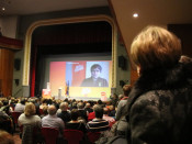 El públic segueix la intervenció en directe del cap de llista de JxCat, Carles Puigdemont, des de Brussel·les, al Teatre Amistat de Mollerussa