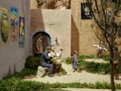 Una part del pessebre on apareix un poble amb cartells de publicitat antics enganxats a la paret