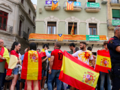 Pla contra-picat de manifestants unionistes a Reus amb banderes espanyoles davant un edifici ple de banderes catalanes, estelades i consignes pel Sí al referèndum