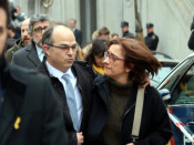 Pla mitjà de Jordi Turull i la seva esposa sortint del Tribunal Suprem envoltats de periodistes