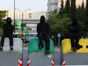 Tres estudiants dalt de contenidors en una barricada en un dels accessos principals a la UAB