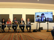 Toni Comín, Meritxell Serret i Lluís Puig amb els advocats belgues de l'equip de la defensa i Carles Puigdemont a la pantalla durant la roda de premsa a Brussel·les el 5 de maig del 2018