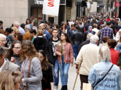 L'Eix Comercial de Lleida, ple de gent passejant, i una parella al mig amb una rosa blanca